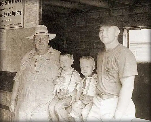 an old black and white photo of two men and two boys